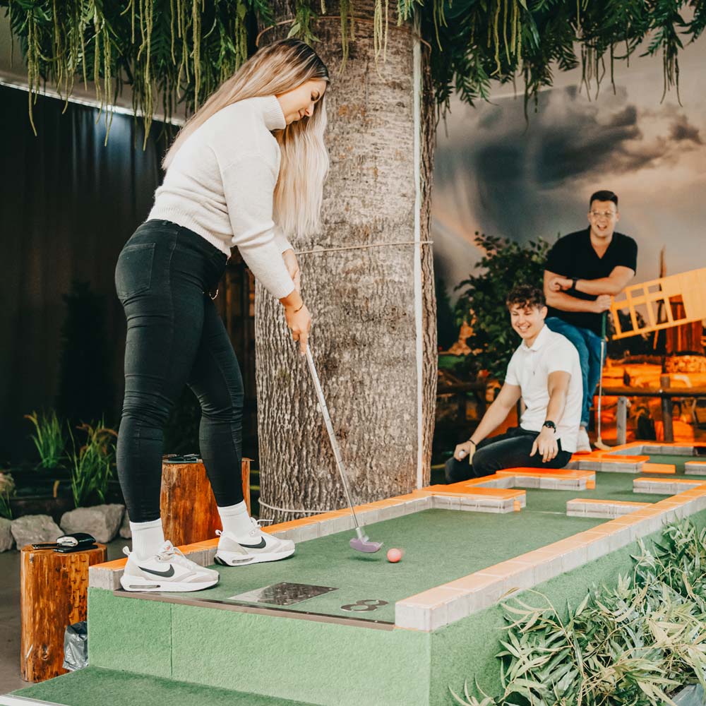 Minigolfia pelaava nainen.