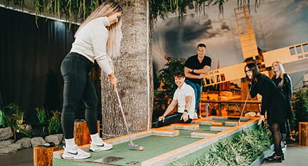 Minigolfia pelaava nainen.