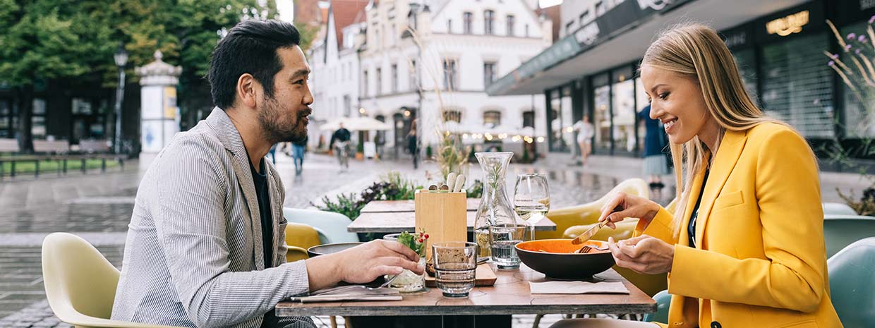Mies ja nainen ruokailevat ulkona ravintolan terassilla Tallinnassa.